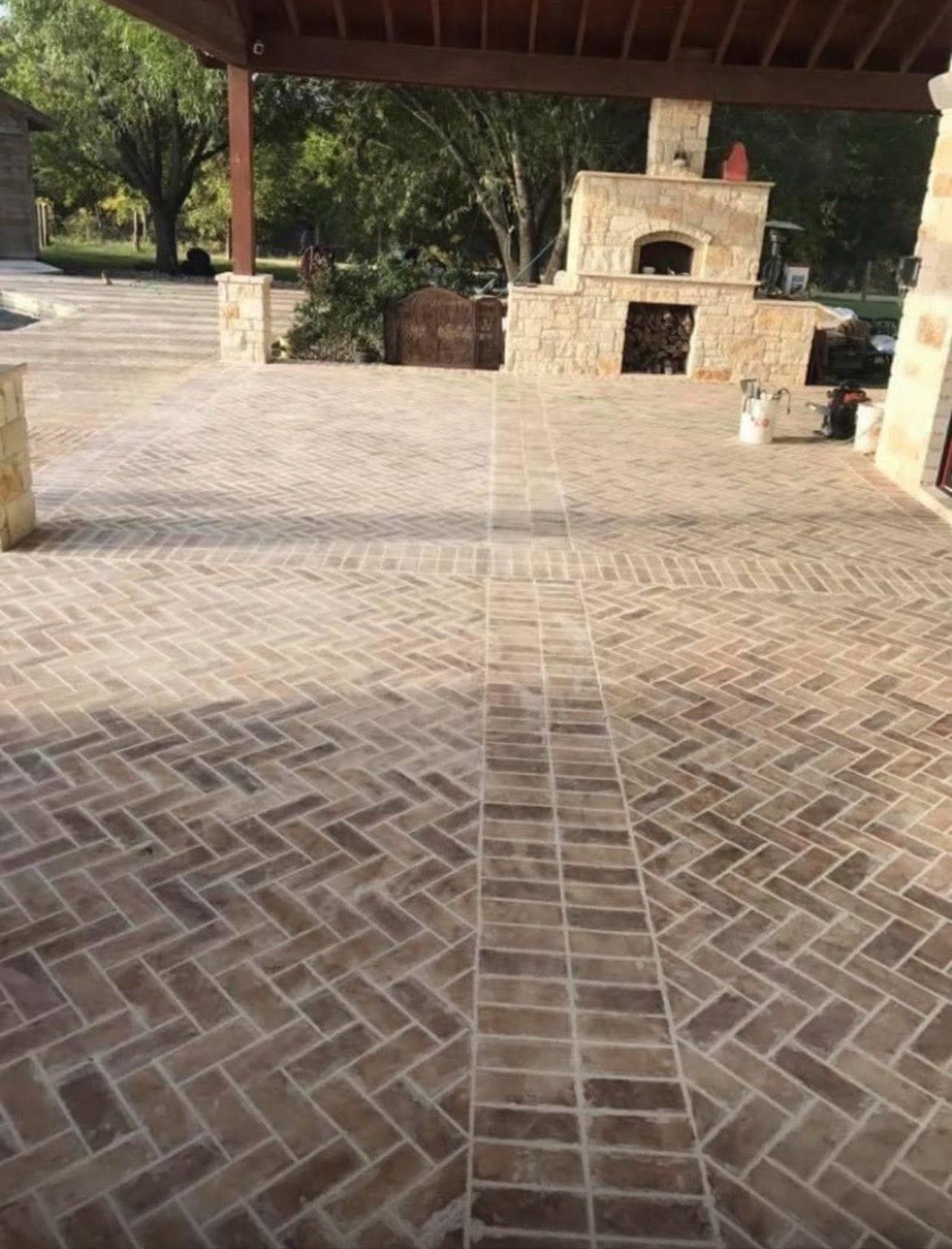 Stone outdoor fireplace and herringbone brick patio